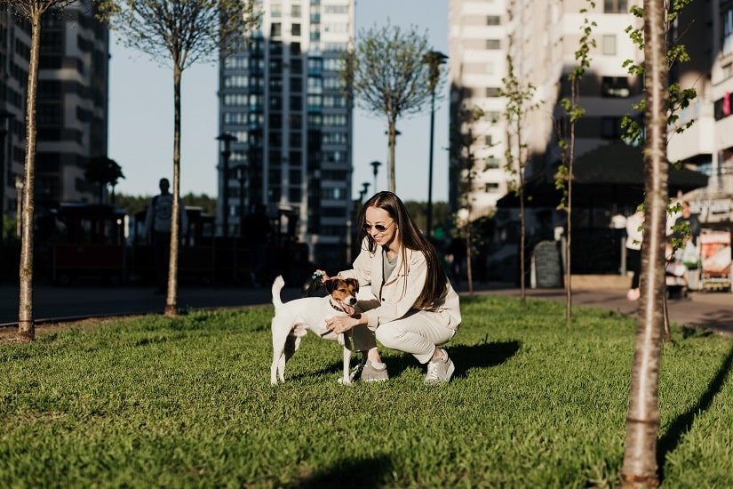 Eine junge Frau mit ihrem Hund in der Stadt